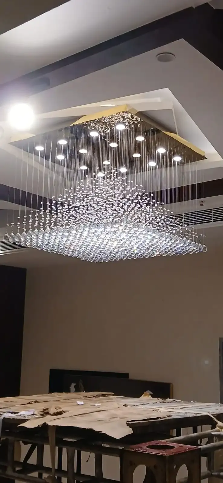 Luxury crystal jhumar chandelier installed in a hotel lobby, premium decorative lighting for hotels and commercial interiors