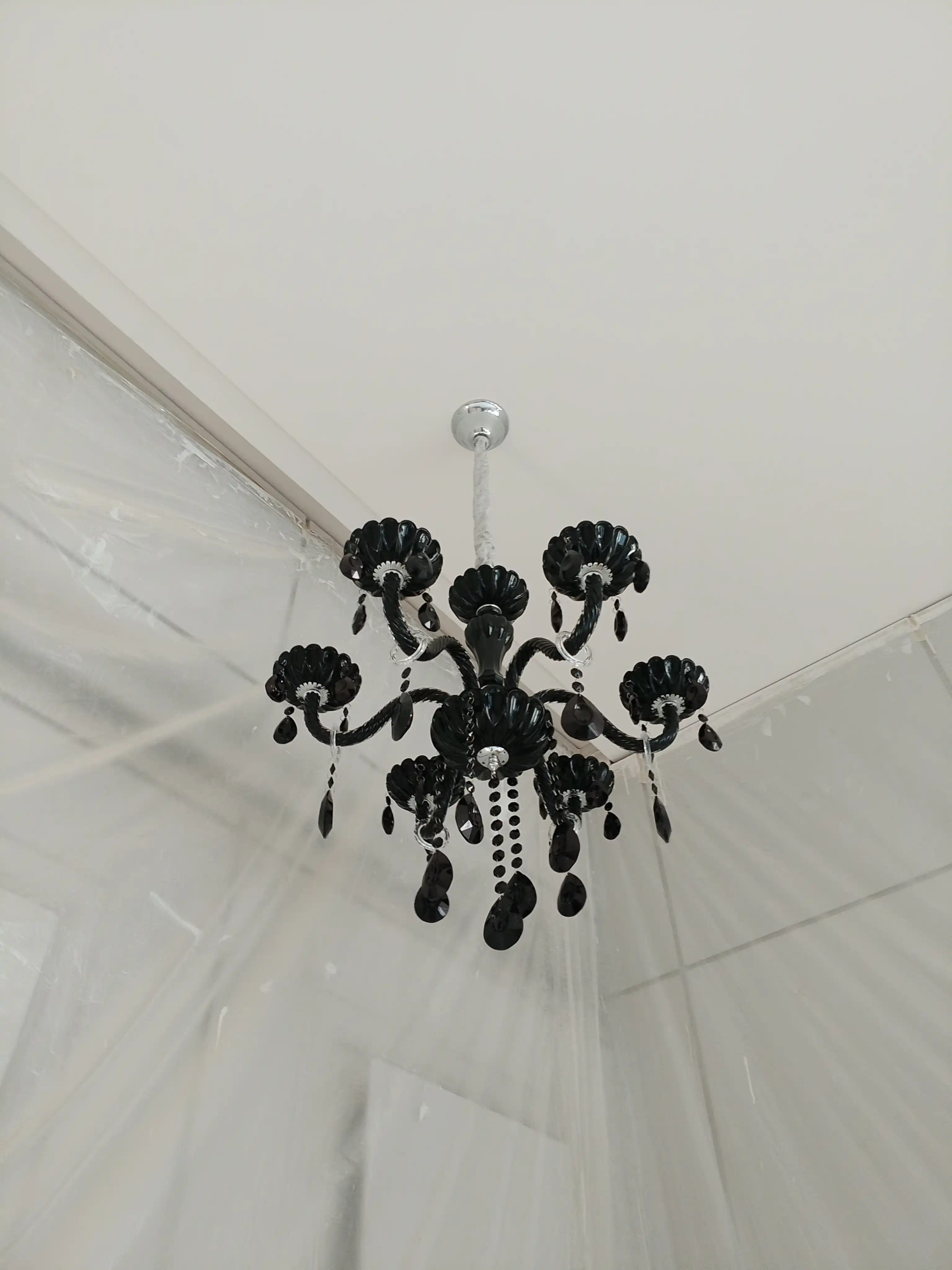Black crystal hanging chandelier installed on a ceiling