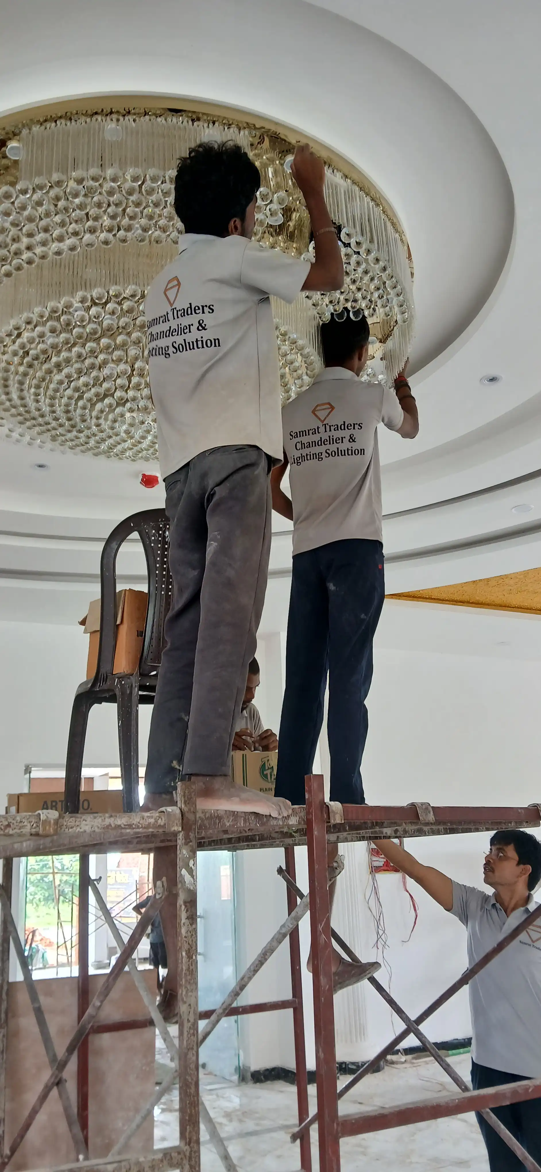 Custom K9 crystal chandelier being installed by Samrat Traders