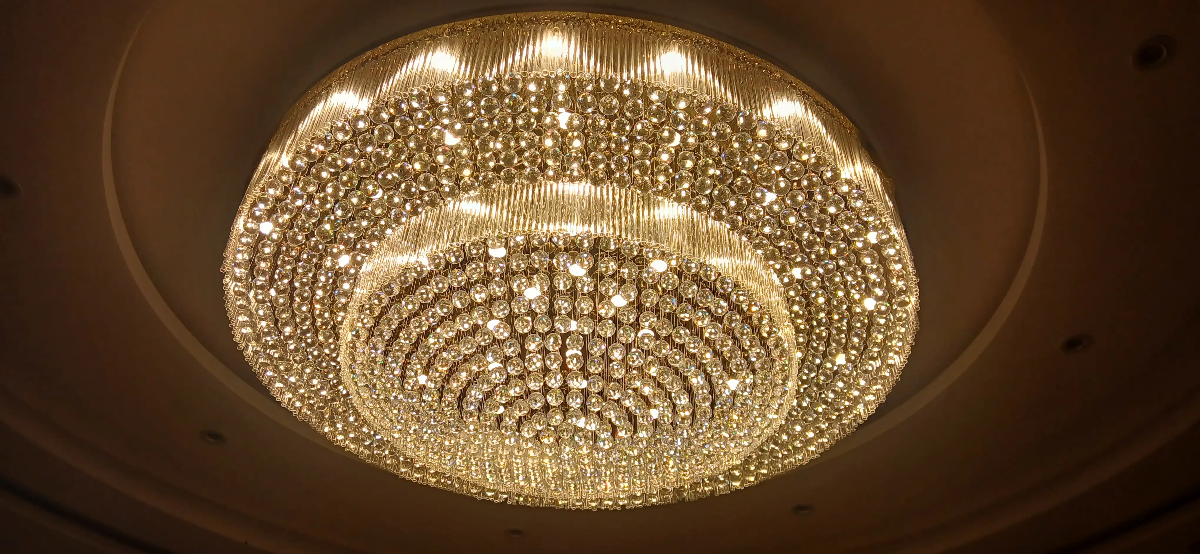 Luxury round crystal chandelier illuminated with warm lighting