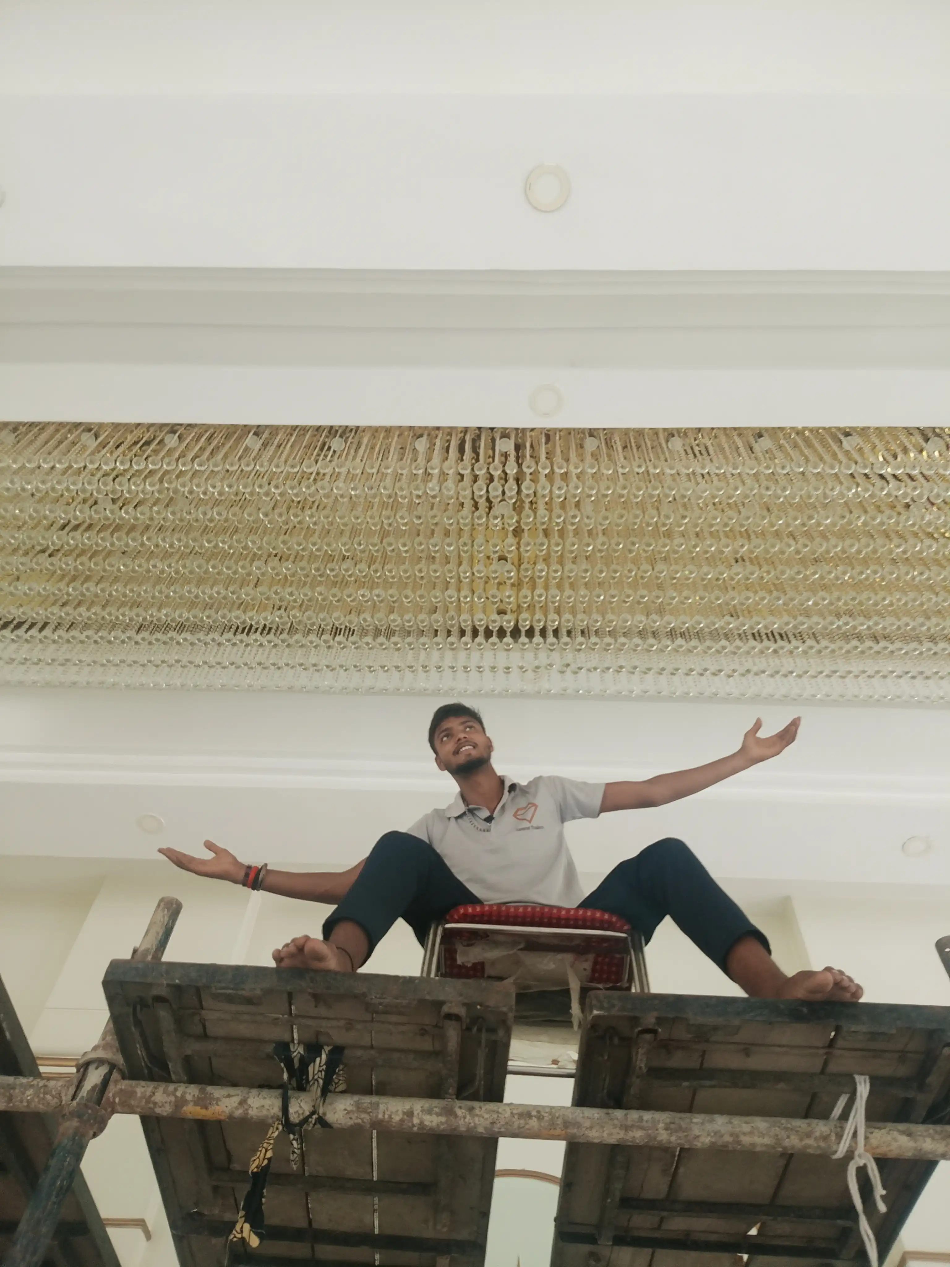 Professional installation of a large custom crystal chandelier using scaffolding