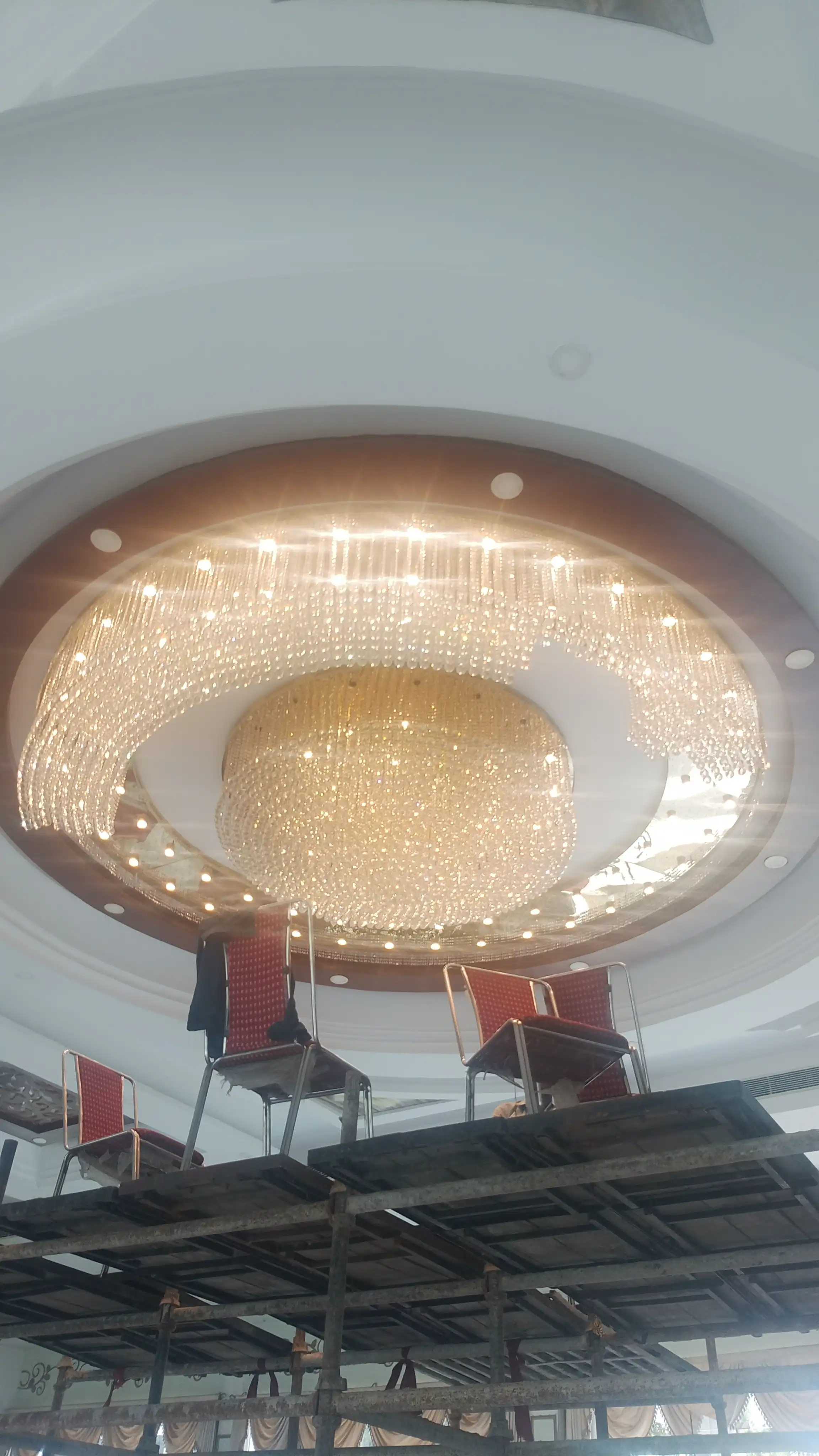 Large custom circular crystal chandelier installed in a luxury banquet hall
