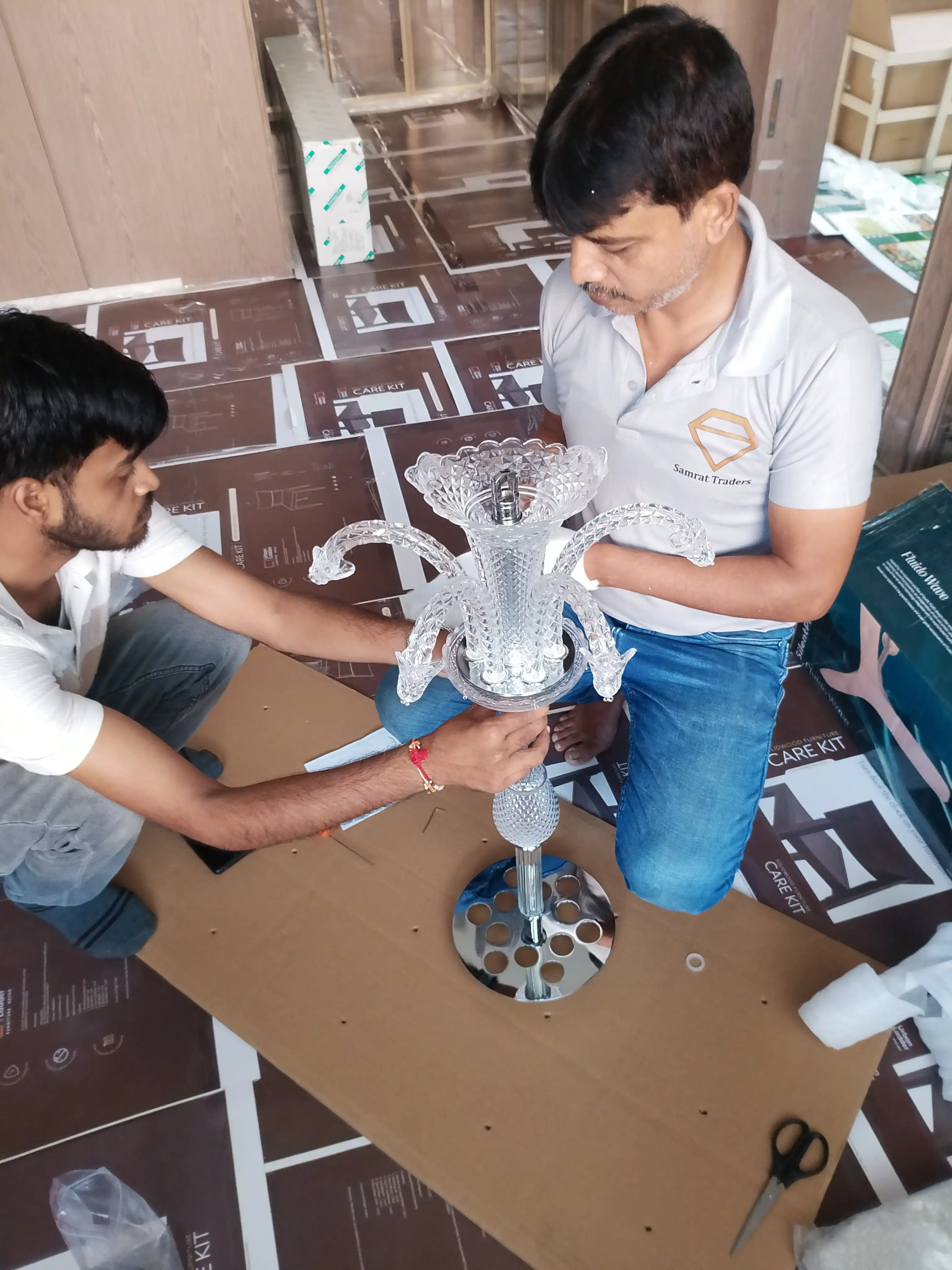 Samrat Traders team assembling crystal chandelier components before installation