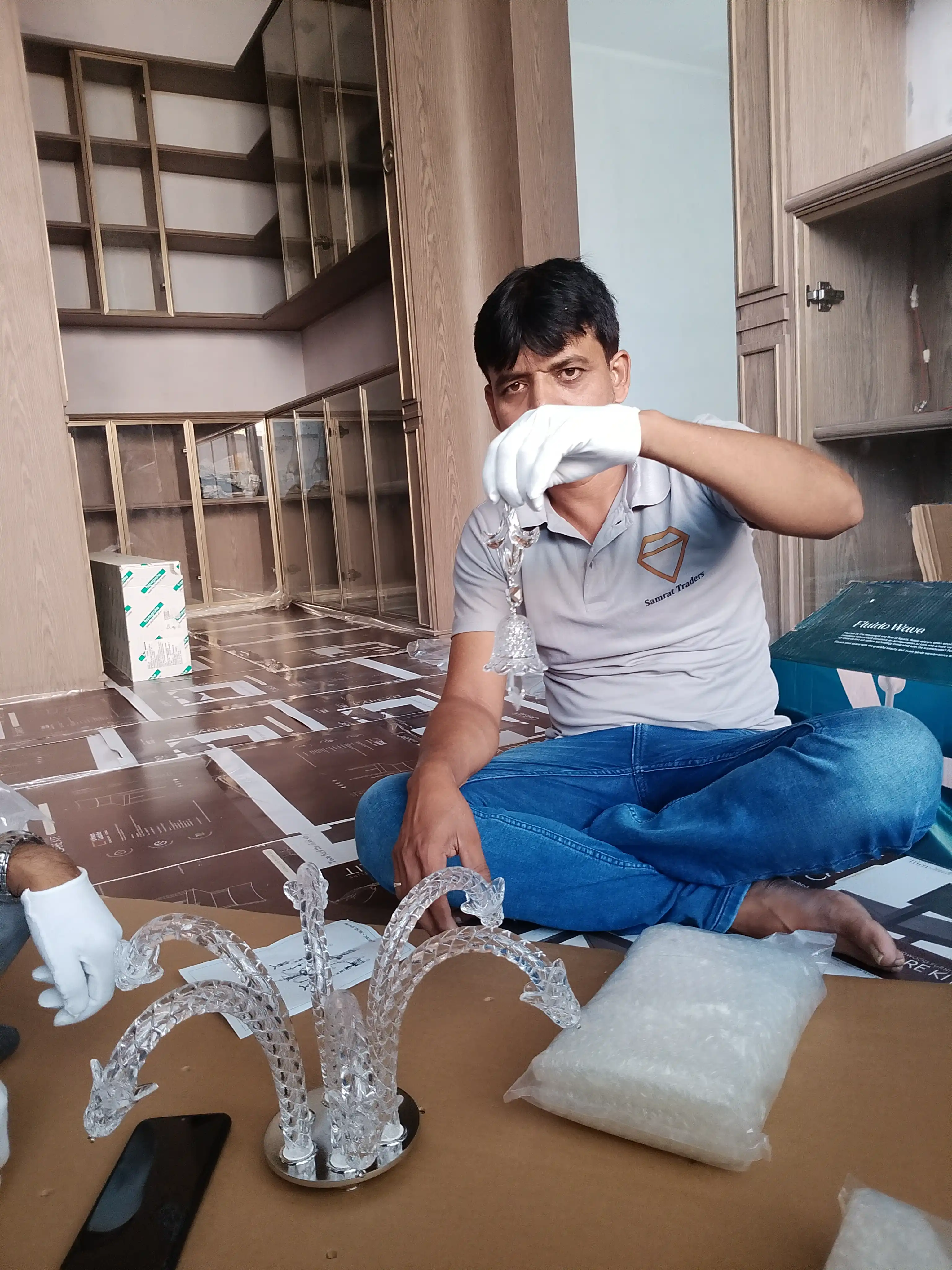 Samrat Traders technician inspecting crystal chandelier components before assembly