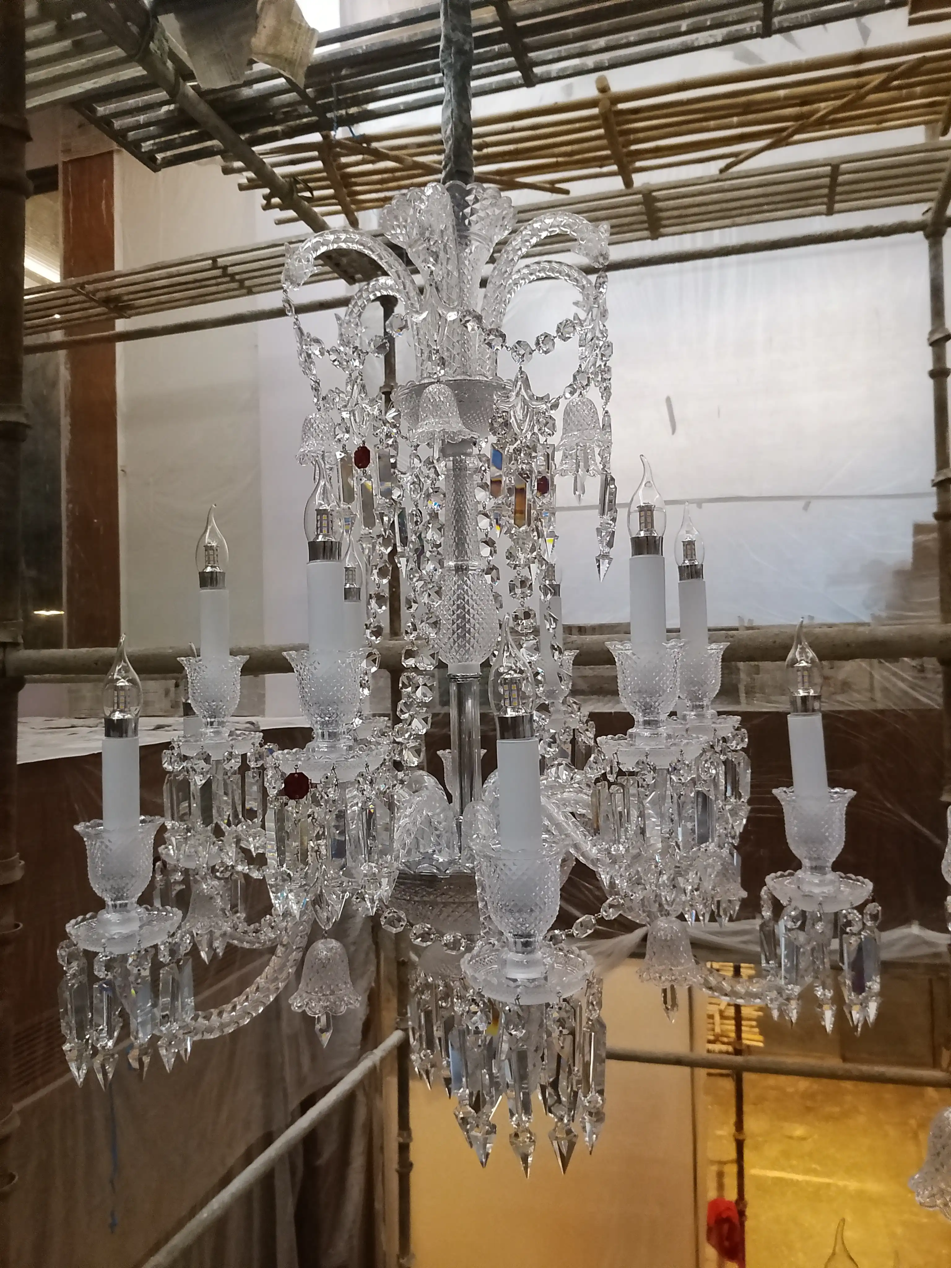 Detailed view of a China imported crystal chandelier during professional assembly and installation