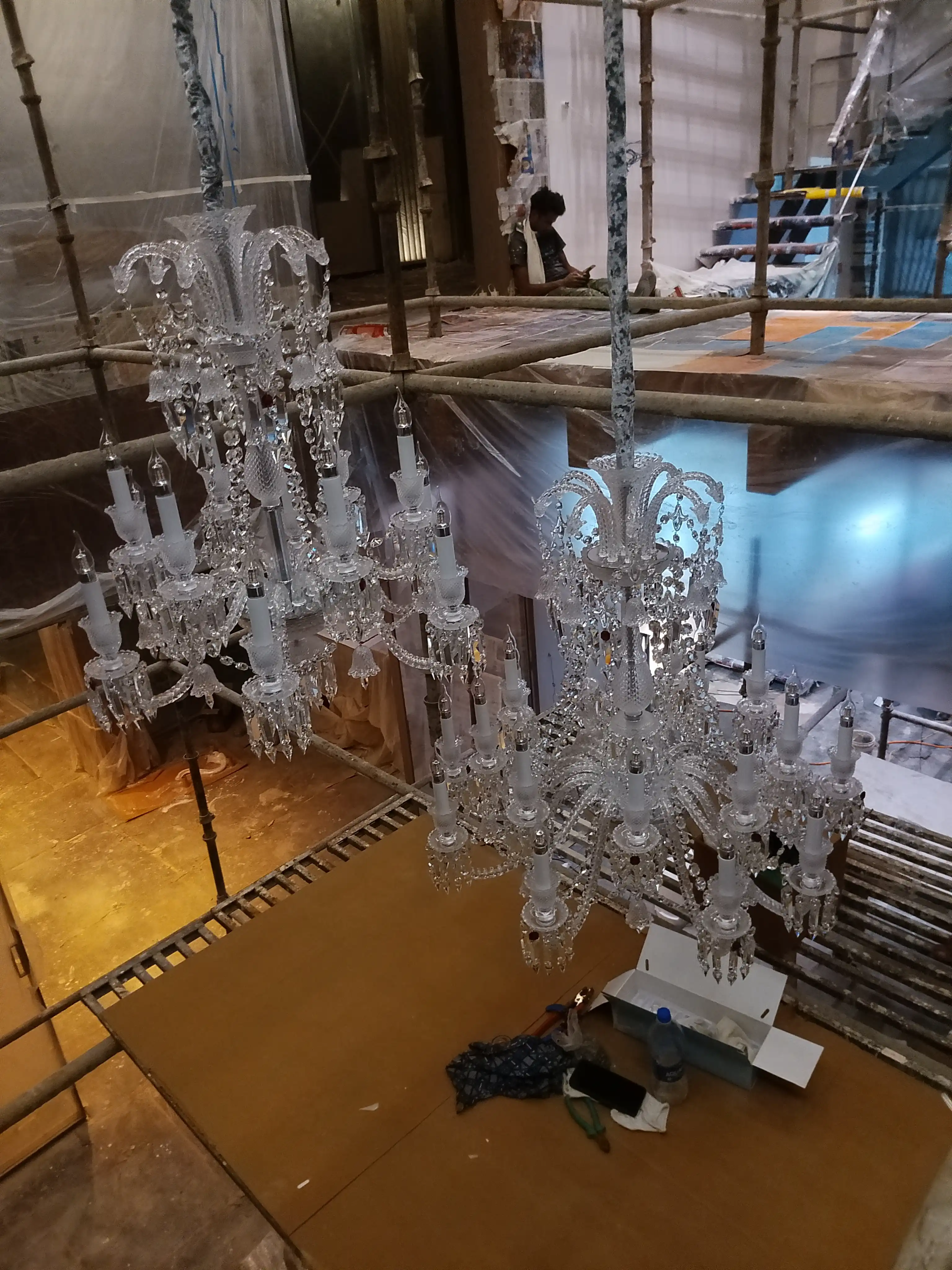 Multiple China imported crystal chandeliers being prepared for installation at a luxury interior project