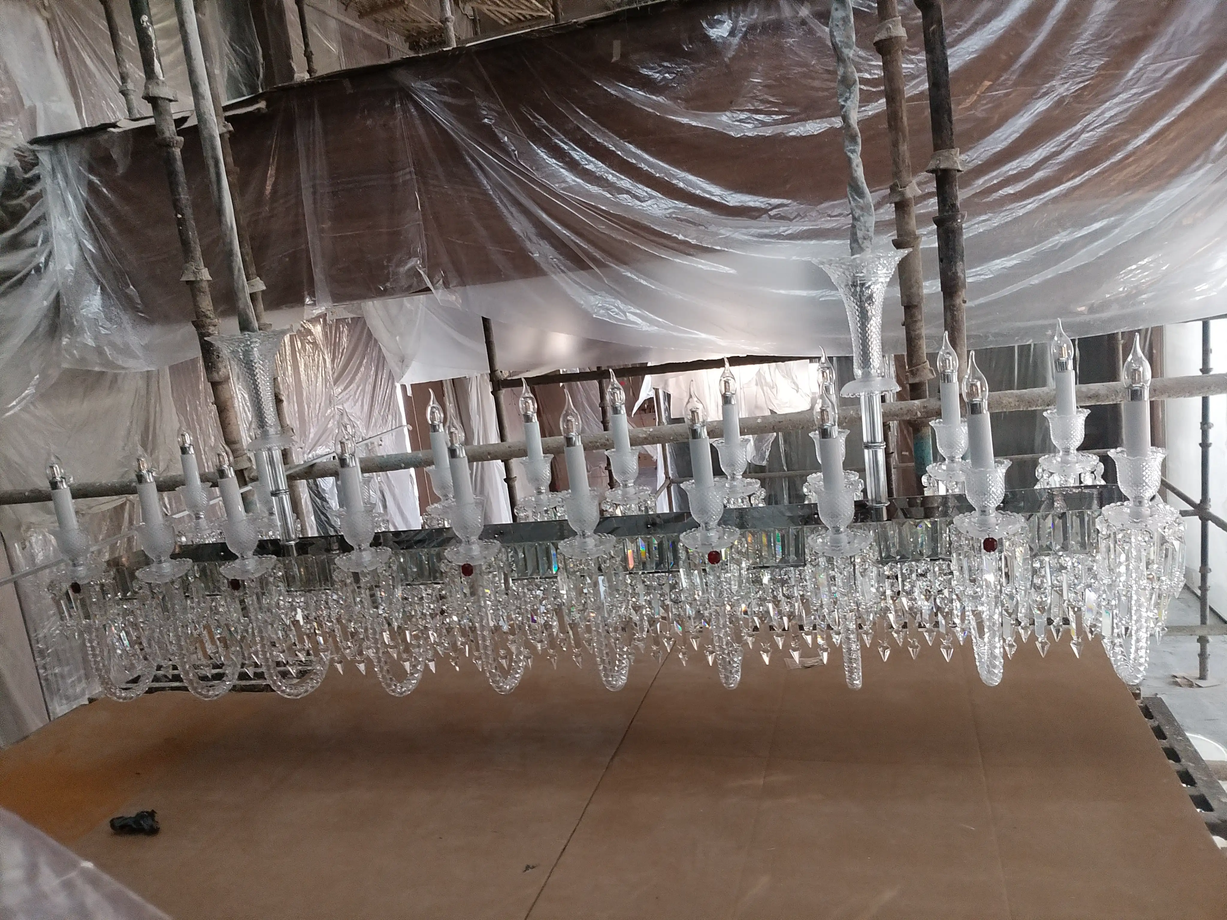 China imported linear crystal chandelier with multiple candle-style lights during assembly